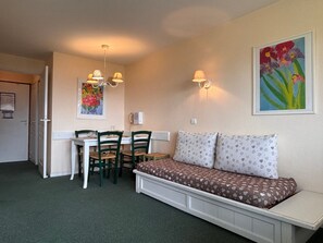A compact room with a dining table, chairs, a sofa, and a painting on the wall. - 2-room ski-in/ski-out apartment, 4-5 ppl, Avoriaz (Avoriaz)