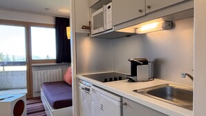 Una kitchenette compacta equipada con microondas, tostadora y pileta.