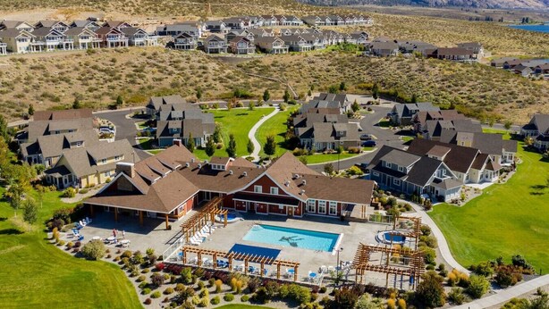 A residential area with houses, a swimming pool, and a well-maintained lawn.