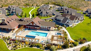 A residential area with houses, a swimming pool, and a well-maintained lawn.