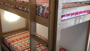 Eine hölzerne Leiterkonstruktion in einem Zimmer mit gemusterten Betttextilien.