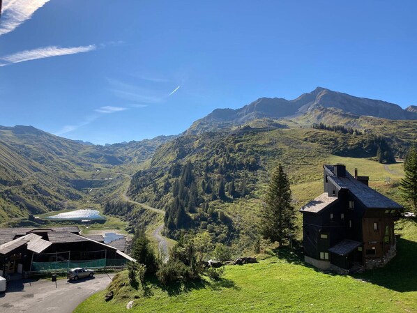 A mountain lodge with a view of a valley and mountains.