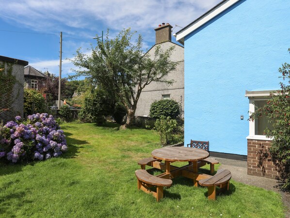 A blue building with a garden, a picnic table, and a small tree. - Maesteg - Llanberis (Caernarfon)