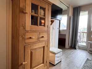 Een houten kast met lades en een televisie erboven.