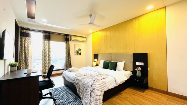 Une chambre d’hôtel avec un lit, un bureau, une chaise et une vue sur la ville.