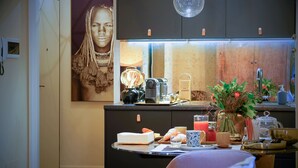 A modern kitchen with a central island, a built-in oven, and a large window above the sink. - My Home For You - Tasso (Bergamo)
