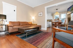 Un salon moderne avec un canapé, une table basse et un coin repas.