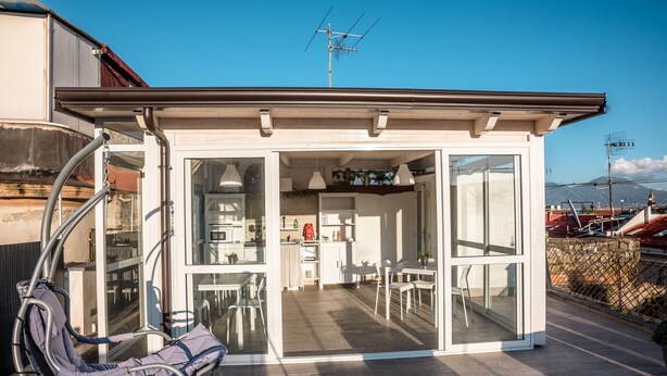 Un espace de vie compact et ouvert, comprenant une cuisine, un coin repas et un coin salon.