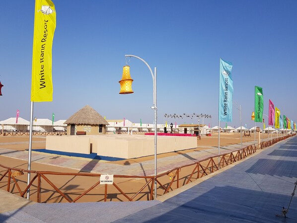 A desert resort with multiple flags, a stage, and a no-smoking sign.