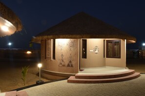 A small, thatched-roof structure with a tiled entrance and decorative wall panels.