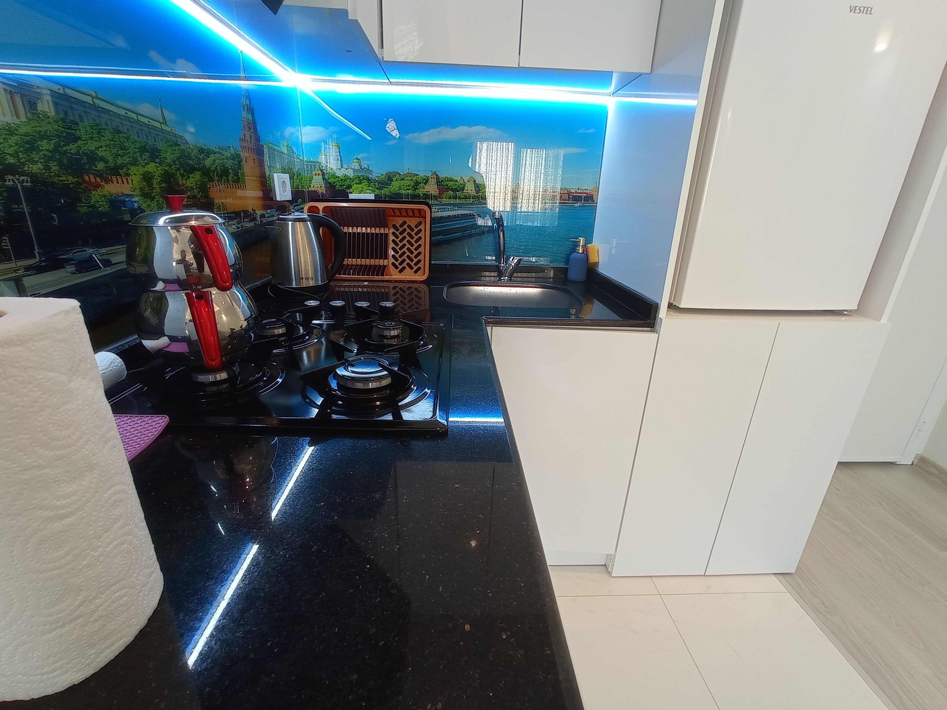 A modern kitchen with a gas stove, a sink, and a decorative backsplash.