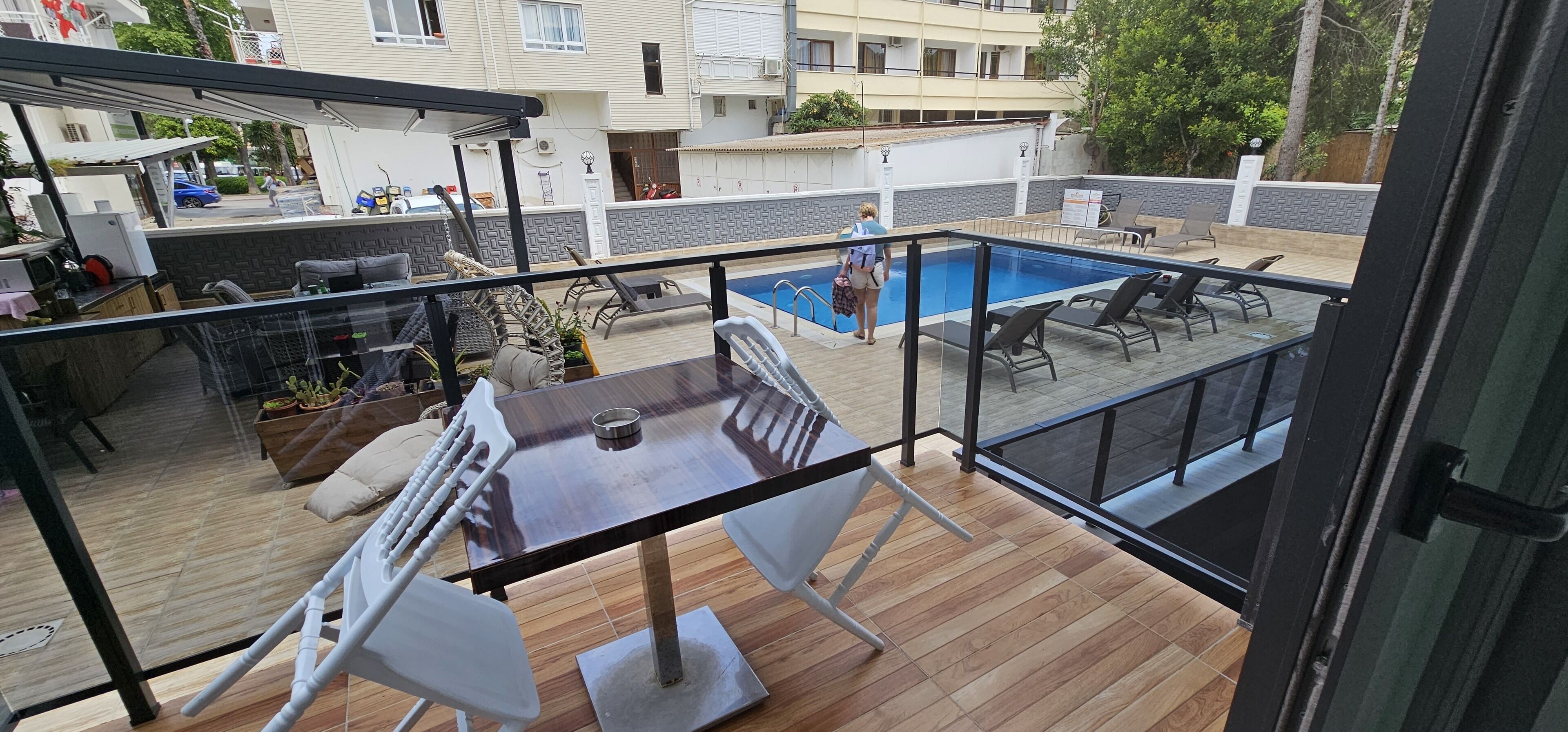 A rooftop patio with a pool, outdoor furniture, and a view of the surrounding buildings.