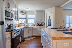 Una cocina moderna con armarios blancos, electrodomésticos de acero inoxidable y una isla de madera.