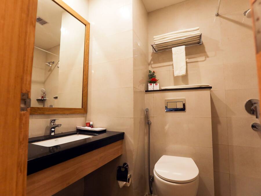 Een badkamer met een wastafel, spiegel, toilet en douche.
