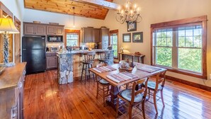 A spacious kitchen with wooden floors, granite countertops, and a central island. - What A View-Mountain Views - Hot Tub - Gas Fireplace (Bryson City)