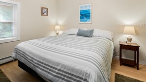 Cozy retreat with a large bed, bedside lamps, and framed artwork.