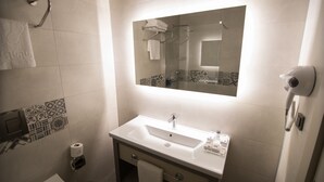 A modern bathroom with a white sink, a mirror, and a towel rack. - Dovv Hotel (Izmir)