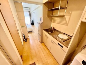 Een koelkast, een microgolfoven, kookgerei, borden en bestek