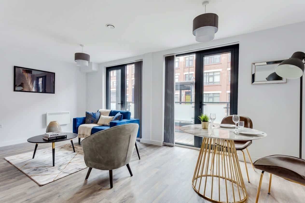 A modern living room with a sofa, a coffee table, and a dining table with chairs.