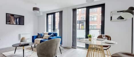 A modern living room with a sofa, a coffee table, and a dining table with chairs.