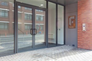 A building entrance with glass doors, a brick wall, and a sign that reads 'FORCE'.