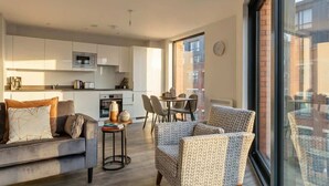 Um apartamento moderno com cozinha, sala de jantar e espaço para sentar.