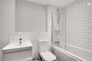 Bathtub, hair dryer, towels, shampoo