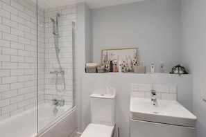 Bathtub, hair dryer, towels, shampoo