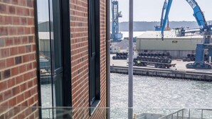 A balcony with a view of a dock and a boat, a brick building, and a sign that reads "ROSE SALLE". - Endless Summer - Spacious Living Space  Poole Quay (Poole)
