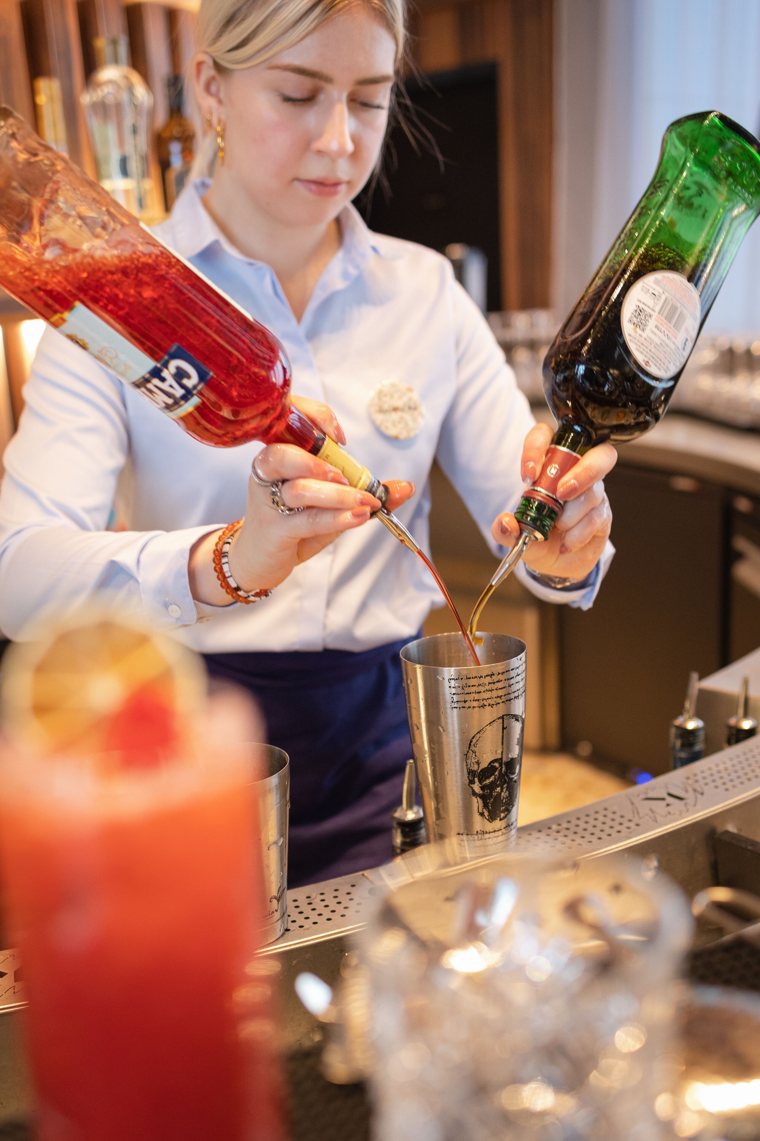 Een barman schenkt een drankje in.