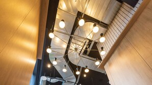A staircase with modern design, metal railings, and a ceiling with exposed ductwork and lighting fixtures. - KOPSTER Hotel Residence Paris Colombes (Colombes)