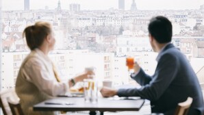 A couple dining at a table with a cityscape view, including a tall tower. - KOPSTER Hotel Residence Paris Colombes (Colombes)