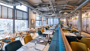 A modern restaurant with a long counter, multiple dining tables, and chairs. - KOPSTER Hotel Residence Paris Colombes (Colombes)