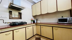 Una cocina con estufa a gas, microondas y armarios de madera.