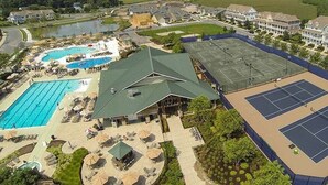 A multi-story building with a tennis court, a swimming pool, and a covered patio area. - Bayside * 5BR Luxury Home (Selbyville)