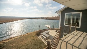 Eine Terrasse mit Blick auf einen Fluss und sanfte Hügel in der Ferne.