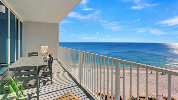 A balcony with a view of the ocean and beach.