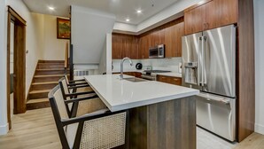 Une cuisine moderne avec des meubles en bois, des appareils en acier inoxydable et un îlot central.