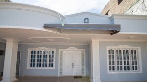 Un bâtiment à la façade bleu clair, doté de colonnes blanches et de grandes fenêtres à carreaux.