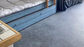 Habitación con literas, una escalera, un escritorio y una lámpara.
