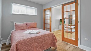 A bedroom with a bed, a window, and a door leading to an outdoor area. - LowerFlat in GermanVillage - 3BR Pet | Yard | Park (Columbus)