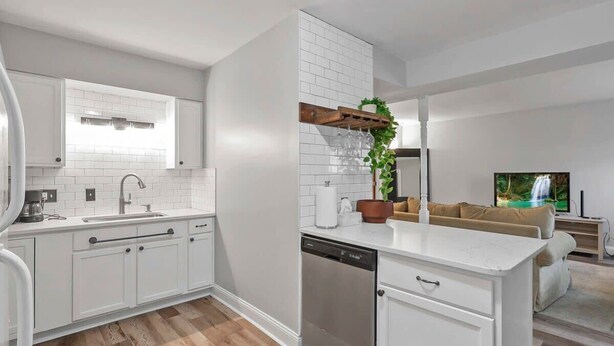 A modern kitchen with white cabinetry, a dishwasher, and a built-in island. - LowerFlat in GermanVillage - 3BR Pet | Yard | Park (Columbus)
