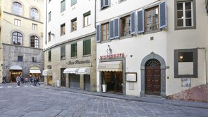 A cobblestone street with storefronts, including a restaurant and a bar. - Pontevecchio Stylish Apartment in Florence (Florence)