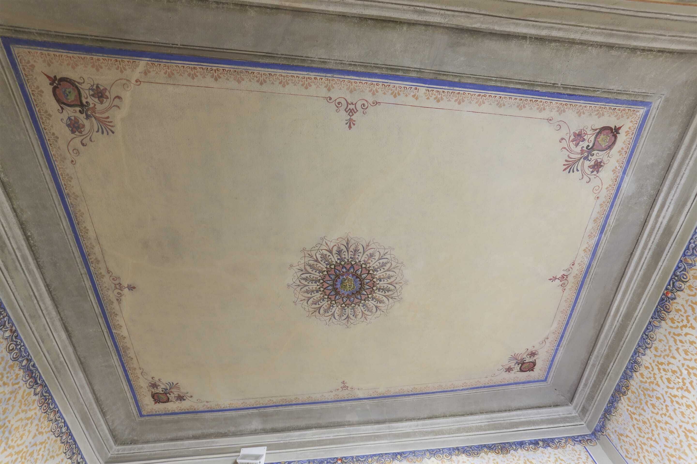 Un plafond orné d’une bordure décorative et d’un médaillon central.