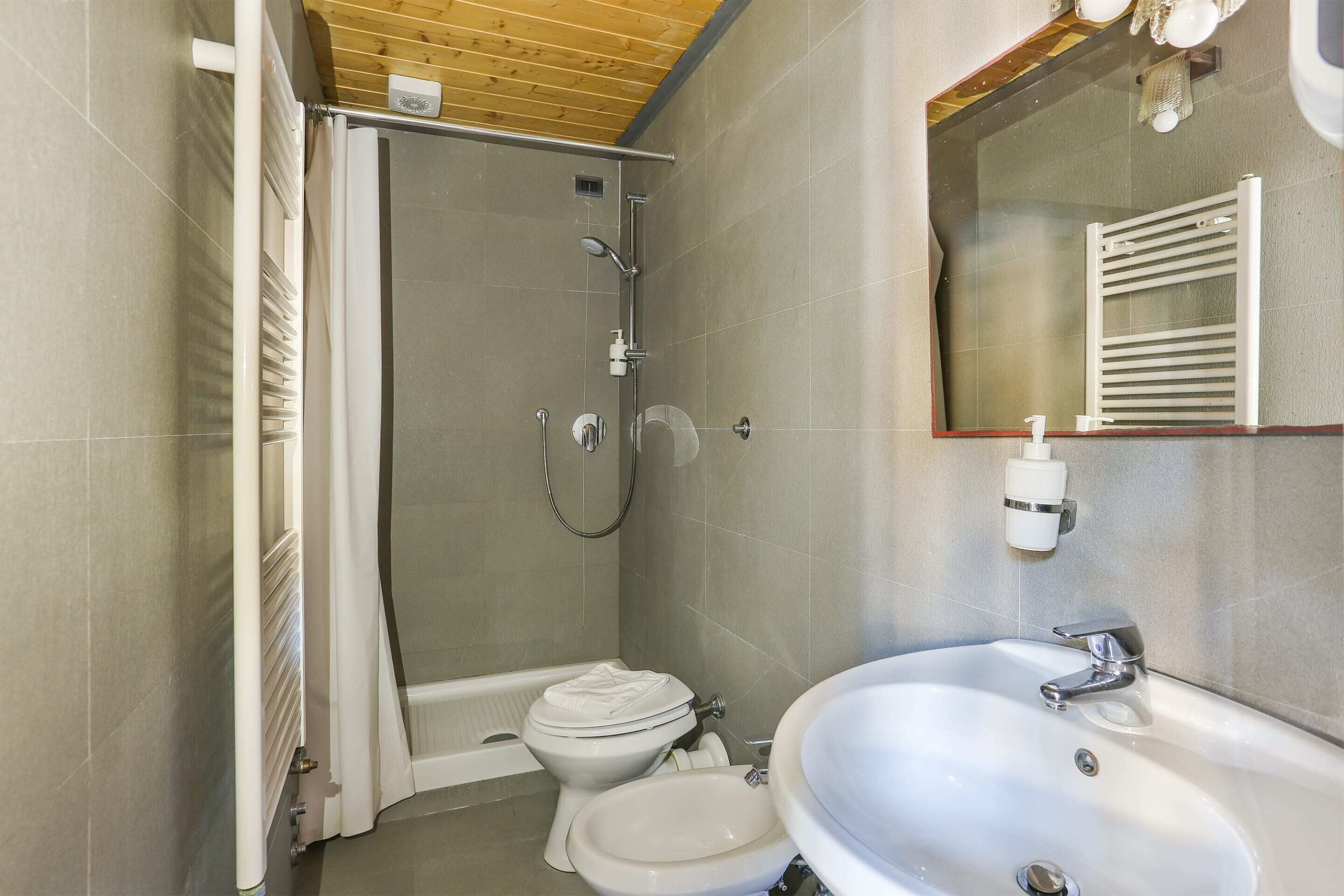 A bathroom with a shower, toilet, and sink.
