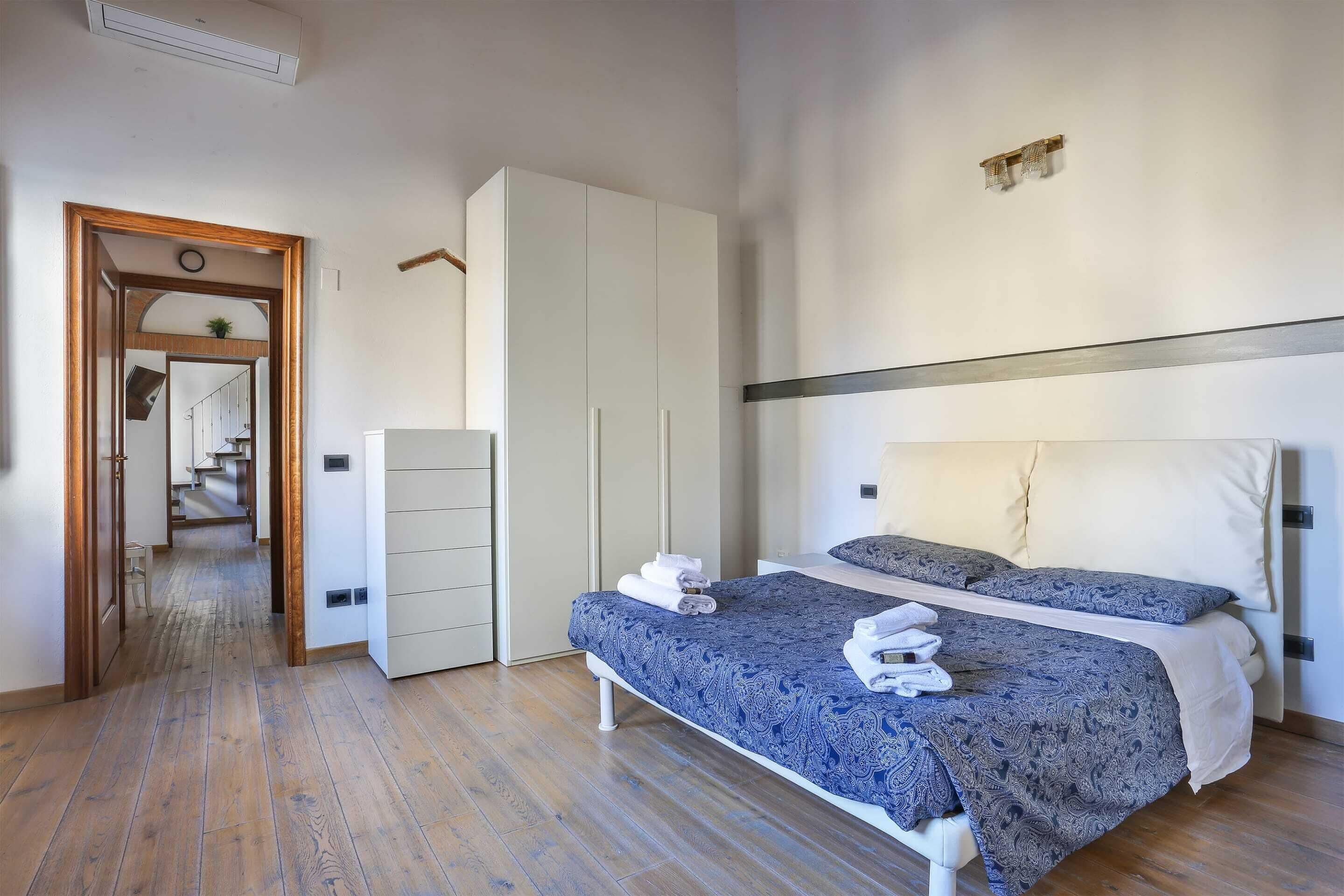 Een slaapkamer met een bed, een kledingkast en een spiegel.