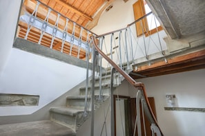 Staircase leads to an upper level with a wooden floor.