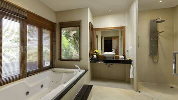 A modern bathroom with a large bathtub, a separate shower area, and a vanity with a sink and mirror.