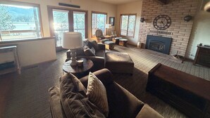 A cozy living room with a fireplace, large windows, and comfortable seating. - Large 3-story LAKE VIEW 4 bedrooms (all masters) & 5 bath Boat Slip & Marina (Bass Lake)