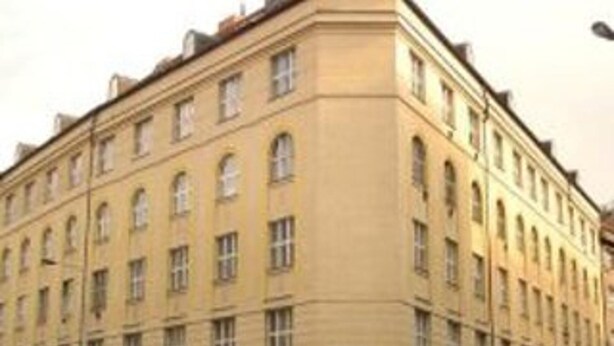 Ein mehrgeschossiges Gebäude im klassischen Stil, mit einer symmetrischen Fassade, gleichmäßig angeordneten Fenstern und einem zentralen Eingang.